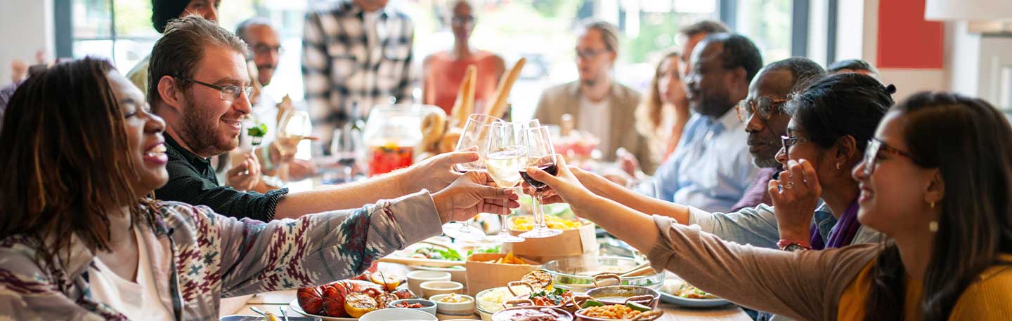 group of friends toasting over a dinner table at a restaurant