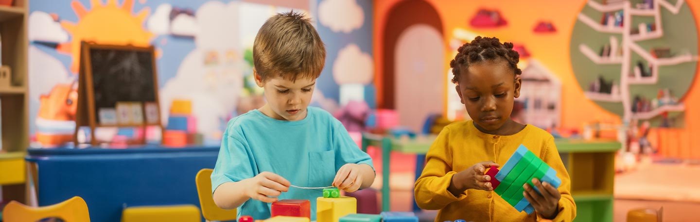 child care activity room with a caucasian boy and african american girl playing with blocks